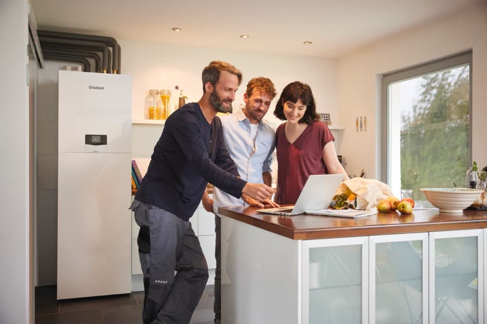 Particuliers regardant un ordinateur guidés par un installateur